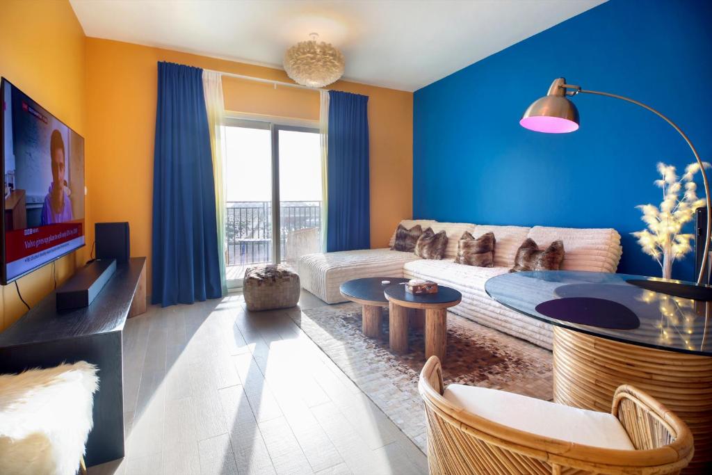 a blue living room with a couch and a table at Silk Valley - Waterfront 2B near Yas attractions in Yas Island