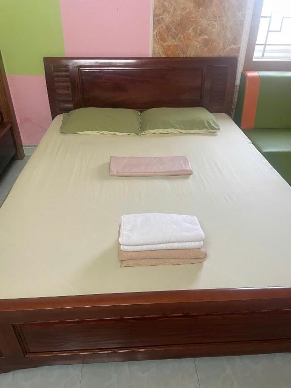 ドンホイにあるHanh Thông Homestayのベッド1台(タオル2枚付)