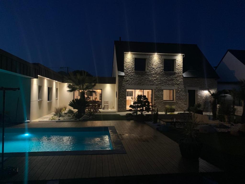 une maison avec piscine la nuit dans l'établissement VILLA de Standing, 10 personnes, Piscine, Spa à 200m des plages, à Brignogan-Plage