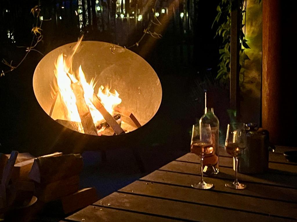 Dos copas de vino en una mesa junto a una fogata en Kleine Landhaus-Perle am Schlosspark, en Eutin