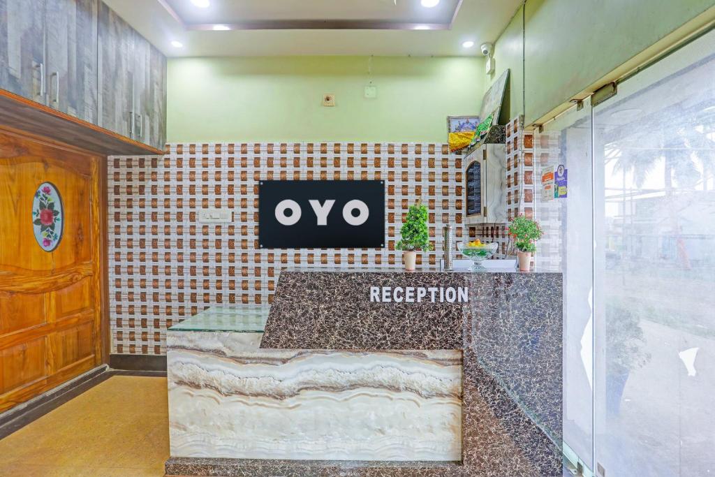 a reception desk in a room with aqo sign on the wall at Hotel O Chandia Palace Kendrapara Railway Station in Kendrāparha