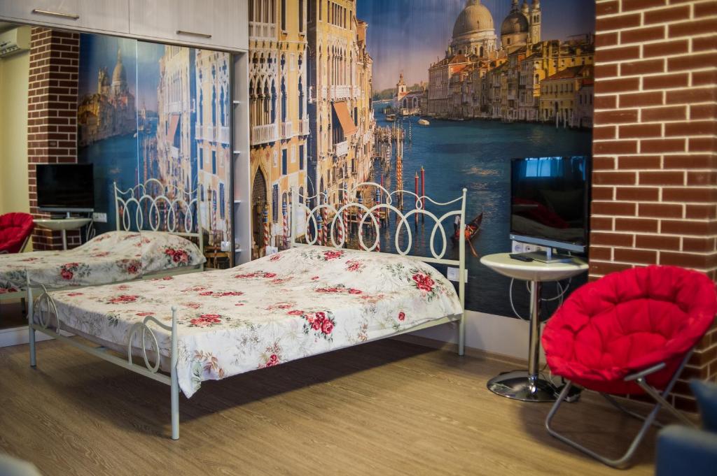 Zimmer mit 2 Betten und 2 roten Stühlen in der Unterkunft Apartment on Takaishvili in Batumi