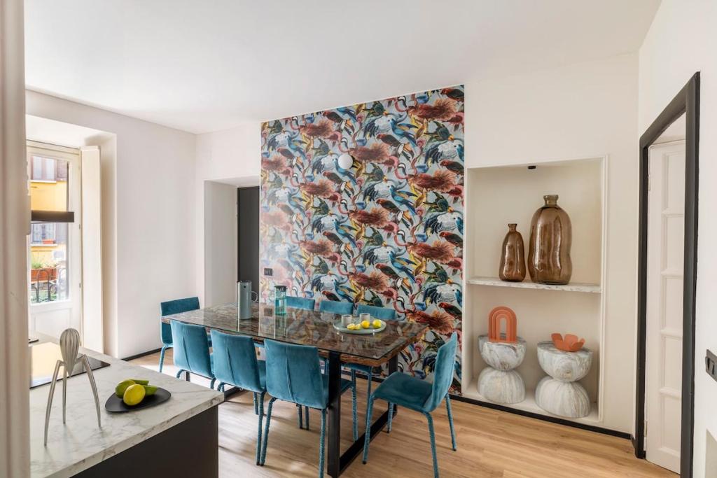 a dining room with a table and blue chairs at Heritage Four Suites in Milan