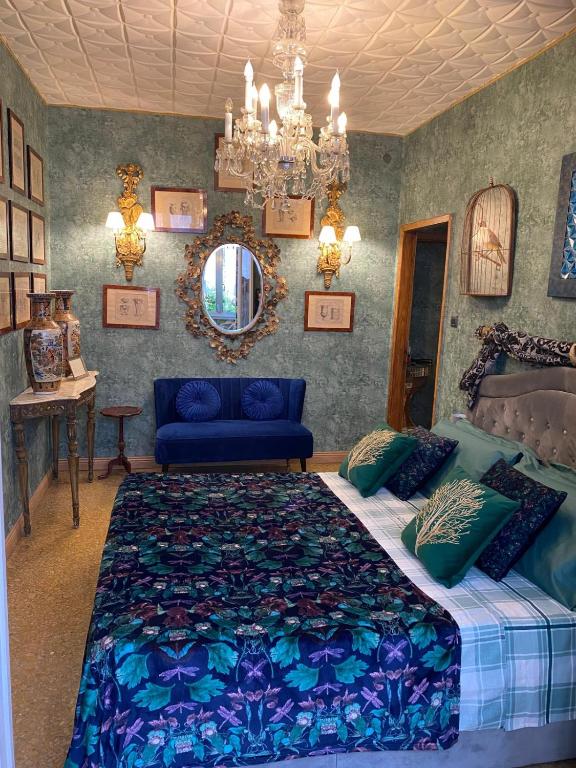 a bedroom with a blue bed and a chandelier at Venetian dream apartment in Venice