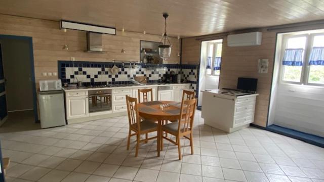 a large kitchen with a table and chairs in it at Le Gîte Saint Girons in Saint-Girons-dʼAiguevives