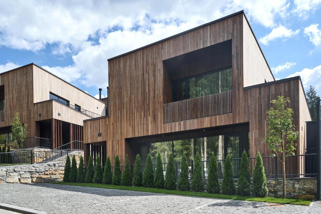 um edifício de madeira com janelas de vidro em uma rua em Chalet Velvet by Fomich em Palyanytsya