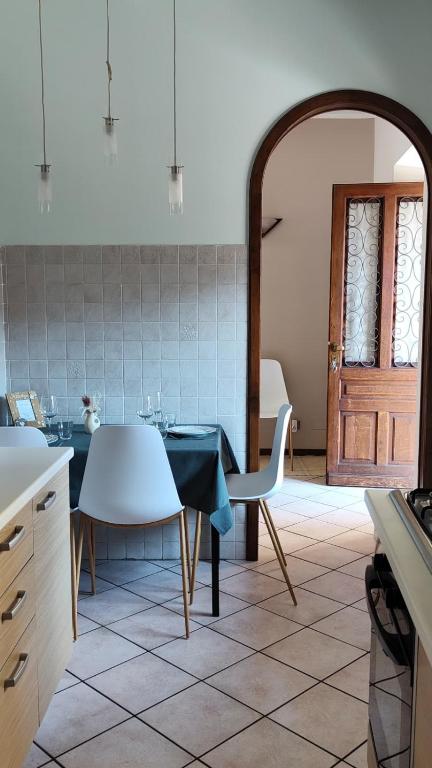 a kitchen with a table and chairs and a door at Bilocale Vecchio Borgo in Borgosesia