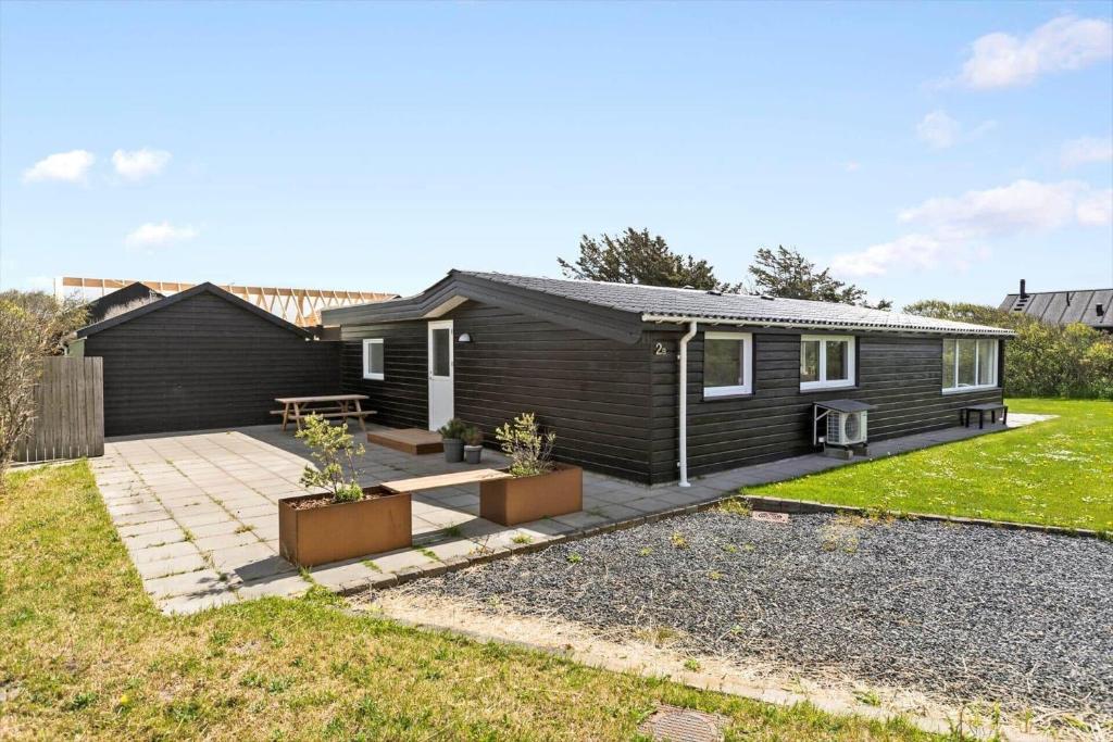 a home with a black house with a backyard at LK1802-Lokken-Septembervej-2-b in Løkken
