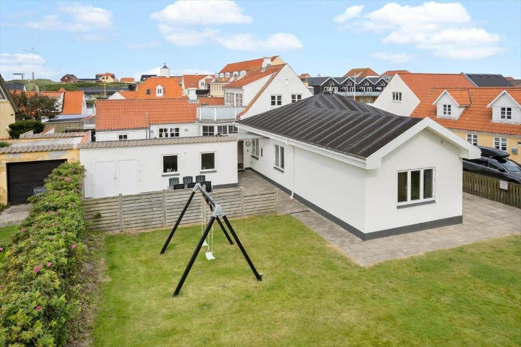 una casa bianca con un cortile di fronte a una città di LK2106-Lokken-Norgesvej-18 a Løkken