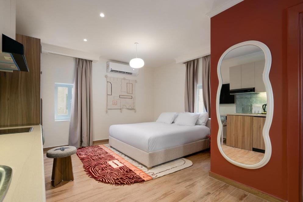 une chambre avec un lit blanc et un miroir dans l'établissement Brassbell l Zamalek l Daoud Studios Villa D, au Caire