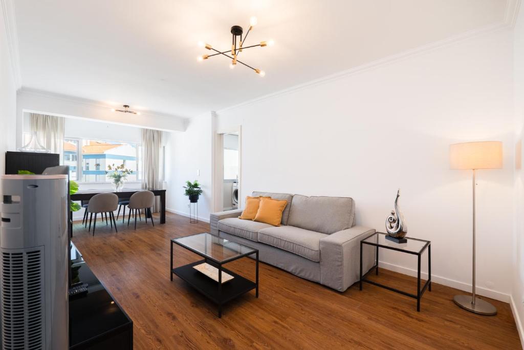 ein Wohnzimmer mit Sofa und Tisch in der Unterkunft Carcavelos Blue Sea II in Carcavelos