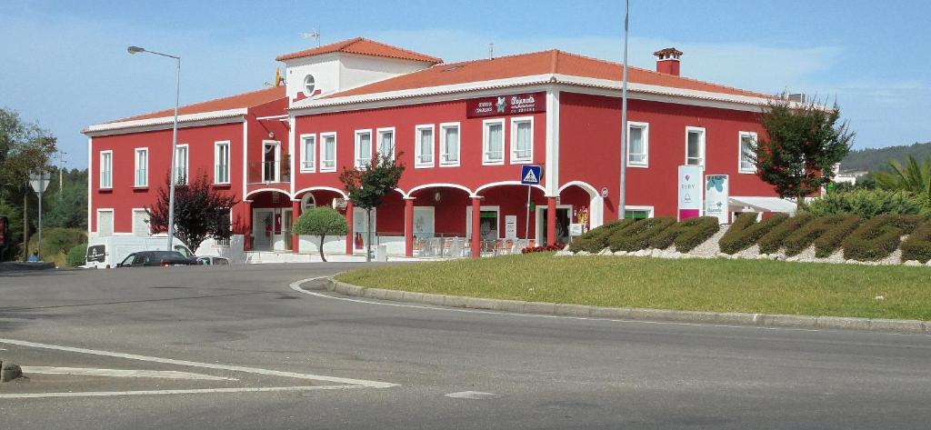 a red building with a street in front of it at Alojamento do Zezere in Ferreira do Zêzere