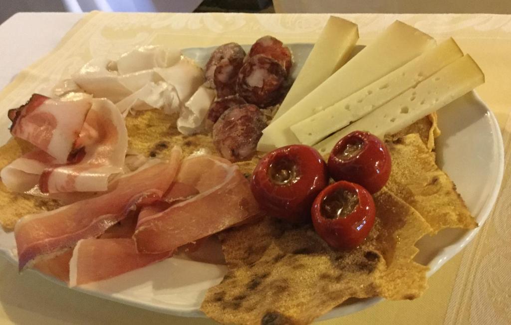 un plato de comida con carne y queso en una mesa en Agriturismo Sa Tiria, en Teulada