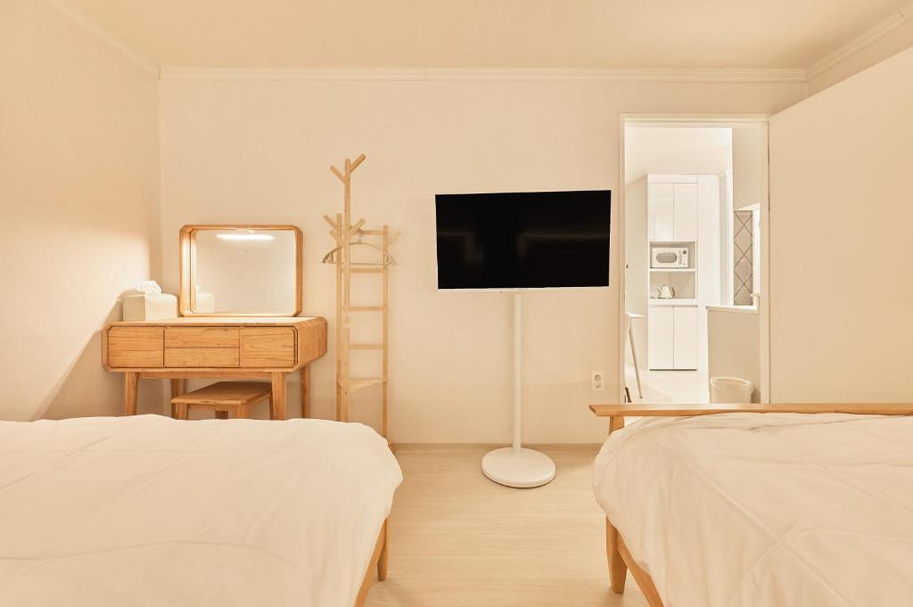 1 Schlafzimmer mit 2 Betten, einer Kommode und einem Spiegel in der Unterkunft Nldam Stay Seoul Station Walk 8min Near Namsan Tower, Easy to Hongdae, Myeongdong,DDP in Seoul