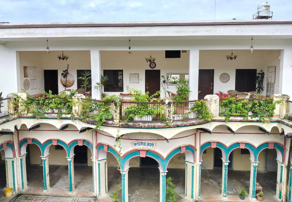 a building with a balcony with plants on it at Khurja Wali Dharamshala in Rishīkesh