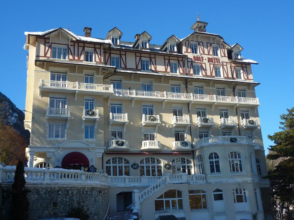 a large white building with a lot of windows at Golf Hôtel in Brides-les-Bains