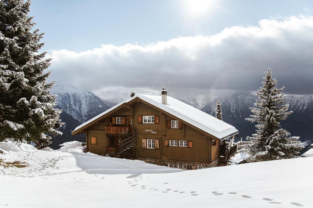 a wooden cabin in the snow with snow at Ferienhaus Golmenheim, Riederalp in Riederalp