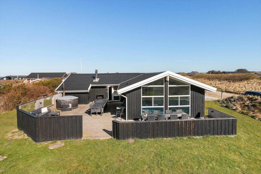 a large house with a deck and a grill at LK2129-Lokken-Diget-18 in Løkken