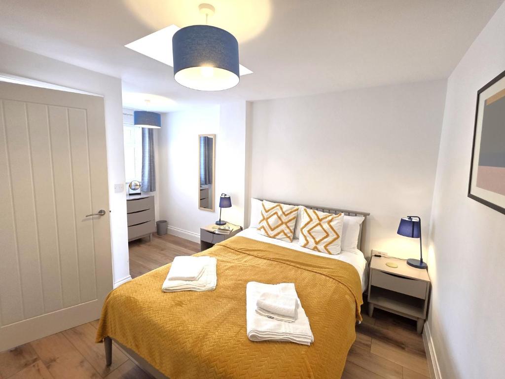 a bedroom with a bed with two towels on it at Modern One Bed Flat at Dawe Luxury Suites - An Entire Apartment near Ely Cathedral & Train Station - The Perfect Gateway to Explore Ely, Cambridge, Norfolk & London - Sleeps up to 4 in Ely