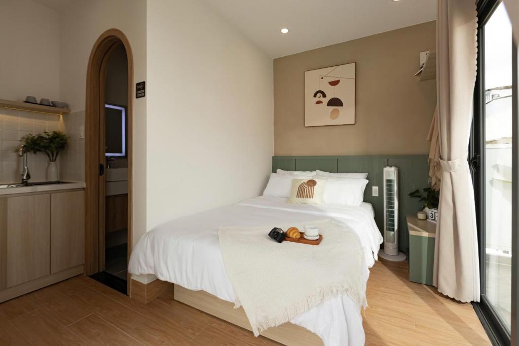 a bedroom with a large white bed and a window at Almira Home Da Lat in Da Lat