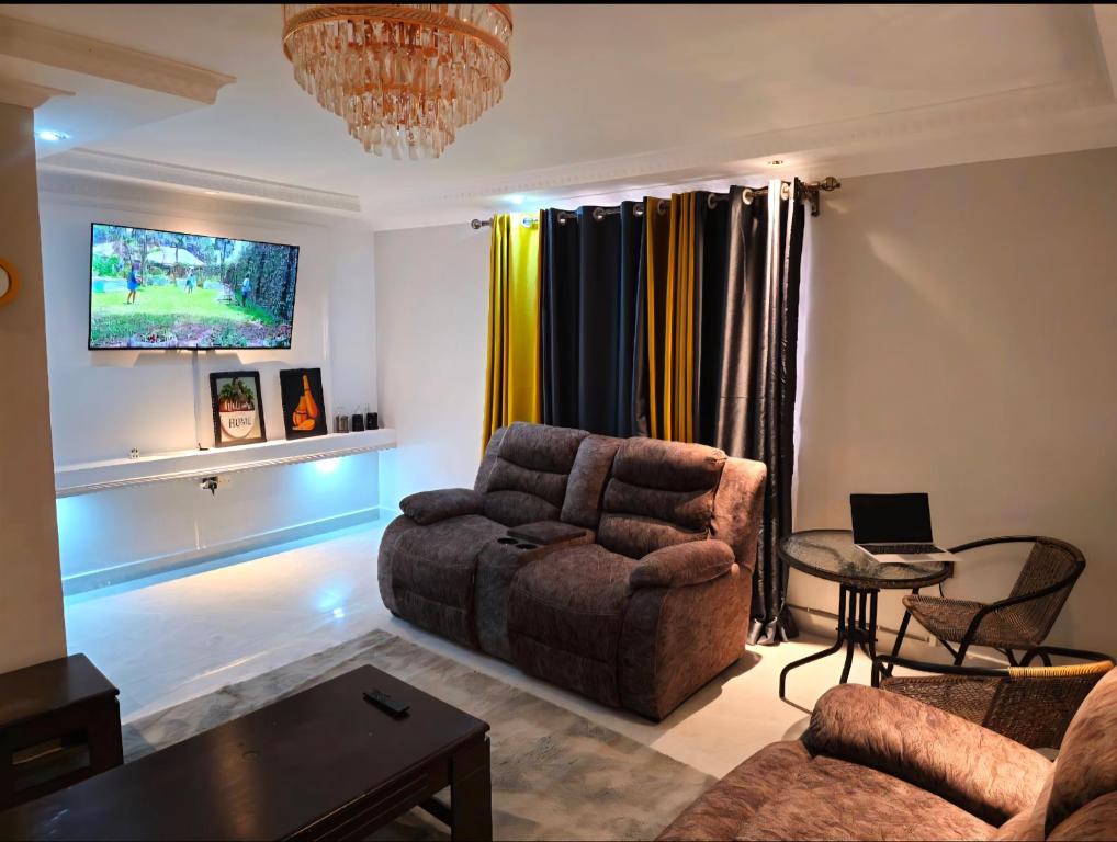 a living room with a couch and a table at Chic Layover Hub 15 min from JKIA Airport in Nairobi