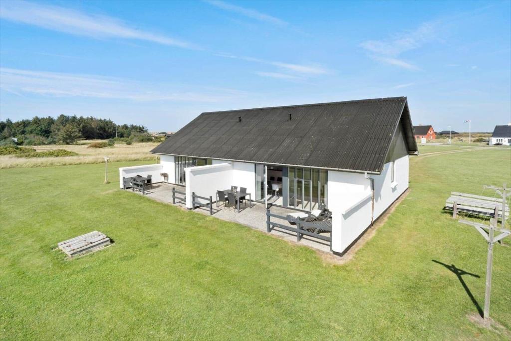 a white building with a black roof in a field at 115-Harboore-Strandvejen-164 in Harboør