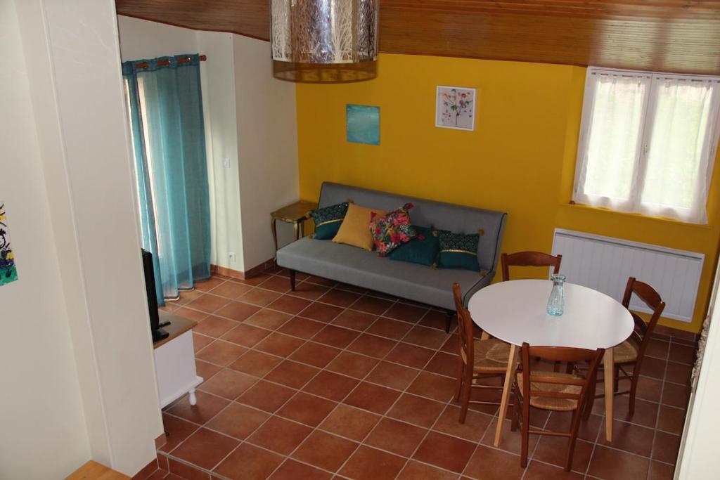 a living room with a couch and a table at La Petite Maison in Orgueil