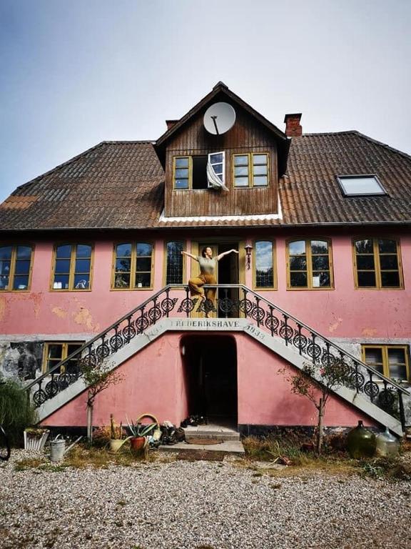 a person standing on the balcony of a house at TroldeSlottet in Rudkøbing