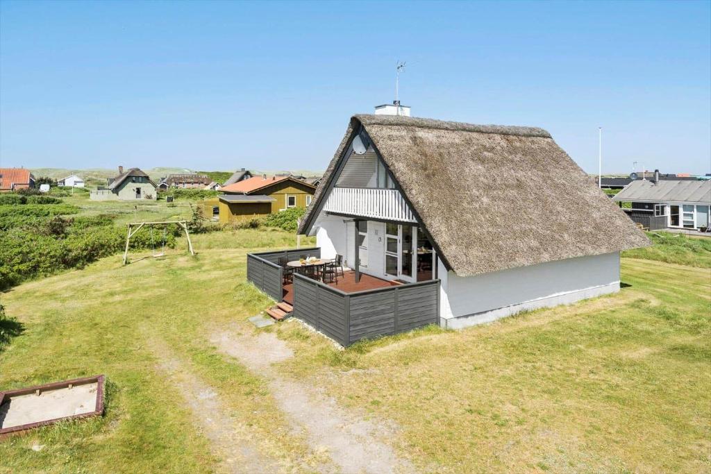 una piccola casa con un tetto in erba su un campo di 300-Harboore-Fourmivej-29 a Harboør