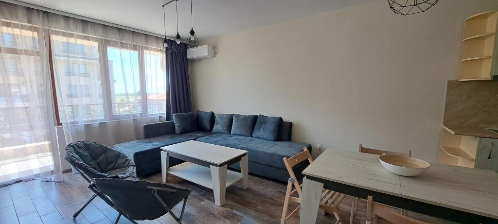 Una sala de estar con un sofá azul y una mesa. en Lighthouse GbA 304, en Balchik