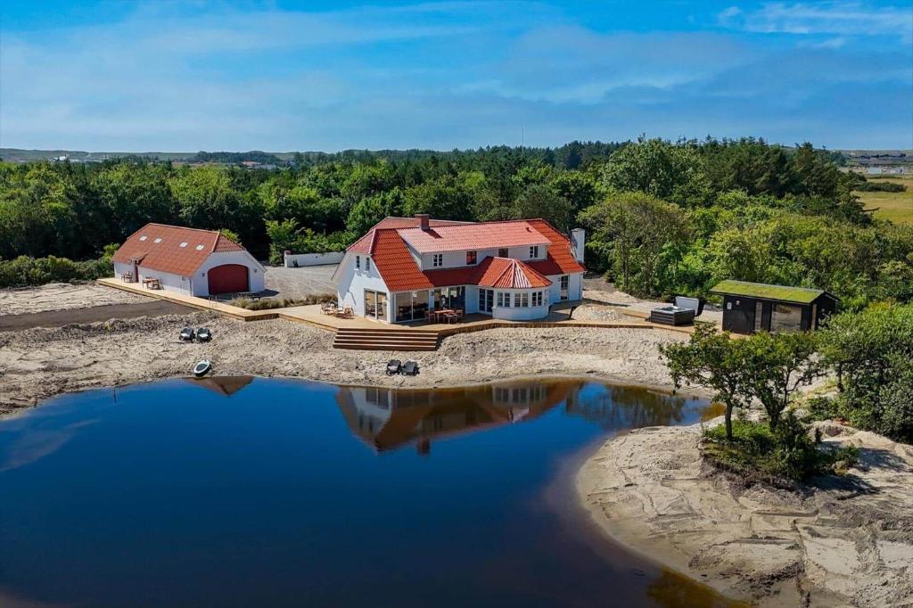 an aerial view of a house with a pond at 266-Harboore-Strandvejen-177-A in Harboør