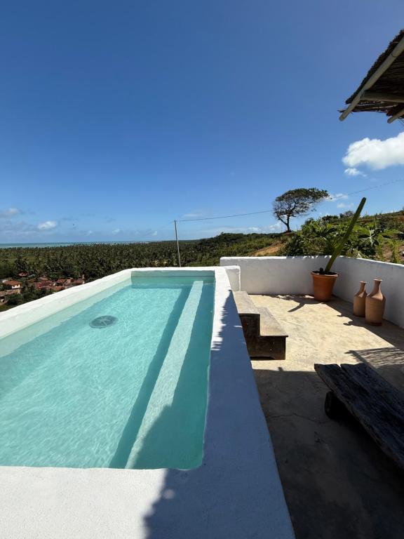 a swimming pool with a view of the ocean at Araxá Milagres in São Miguel dos Milagres