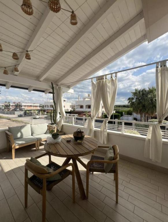a patio with a table and chairs on a balcony at APulia casa e cucina in Trani