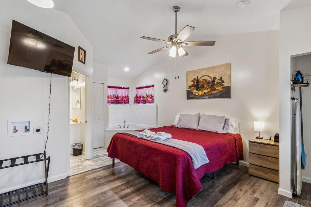 une chambre avec un lit et un ventilateur de plafond dans l'établissement Merlot Cottage - GOTL Strip - Lover's Retreat, à Geneva
