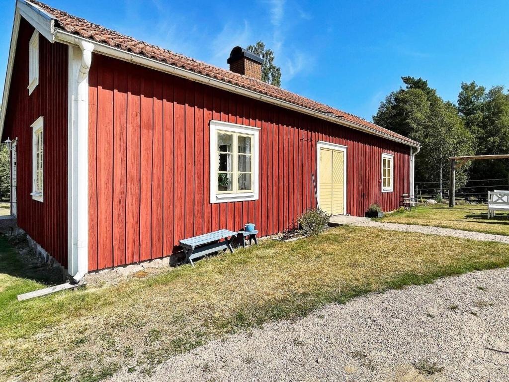 a red building with a bench in front of it at 4 person holiday home in FURUBY in Furuby
