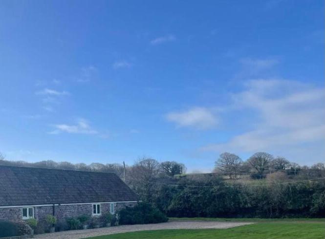 a house in a field next to a building at Barton Cottage in Bridgwater