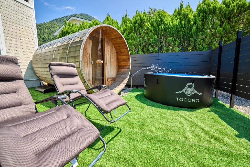 a backyard with chairs and a hot tub and a yurt at TOCORO Mt Fuji Shizuku in Oishi