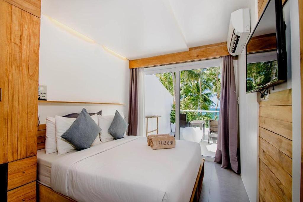 a bedroom with a white bed with a box on it at Zuzuni Boutique Hotel in Boracay