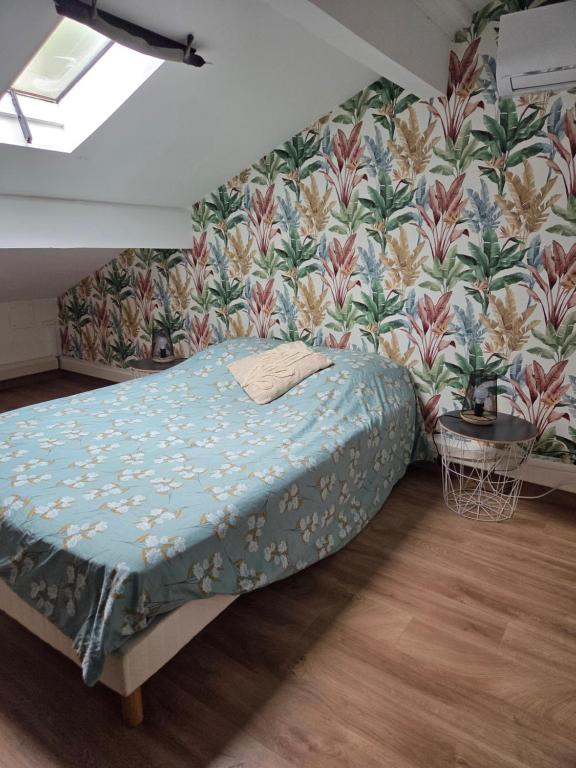 a bedroom with a bed and a floral wall at les chambres de Mélis in Crémieu