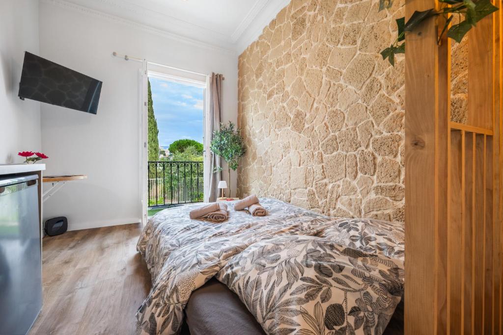 Un dormitorio con una cama y una pared de piedra. en Cocon Azur Nice - Studio à 300m des Plages, en Niza