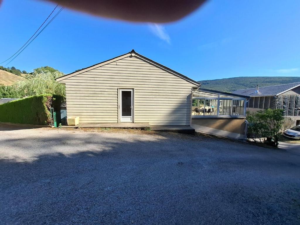 a white house with a porch and a driveway at Maison de vacances in Lacaune