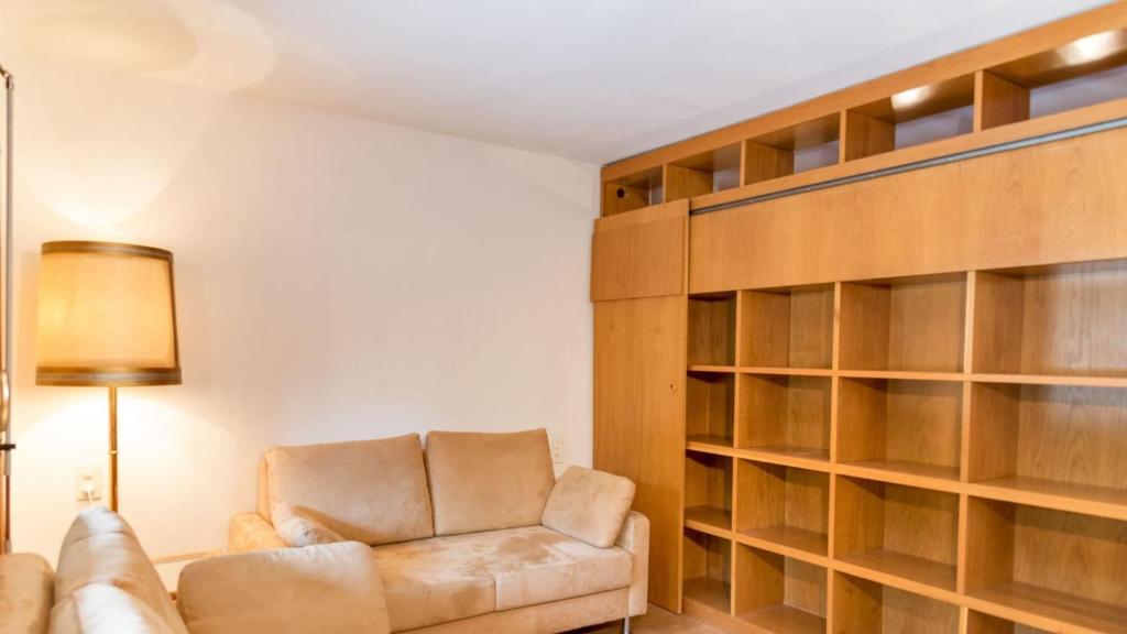 a living room with a couch and a book shelf at Chesa Sarvit 2 - Celerina in Celerina