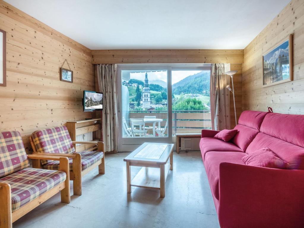 una sala de estar con un sofá y una mesa en Luminosité et espace, 2 pièces, centre village, proche pistes, ascenseur - FR-1-304-14, en La Clusaz