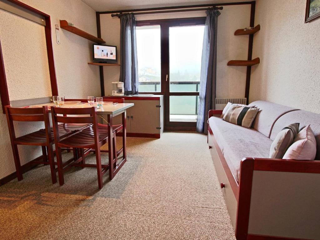 un soggiorno con tavolo, divano, tavolo e sedie di Studio 19m² à Chamrousse avec balcon, parking inclus - FR-1-340-146 a Chamrousse