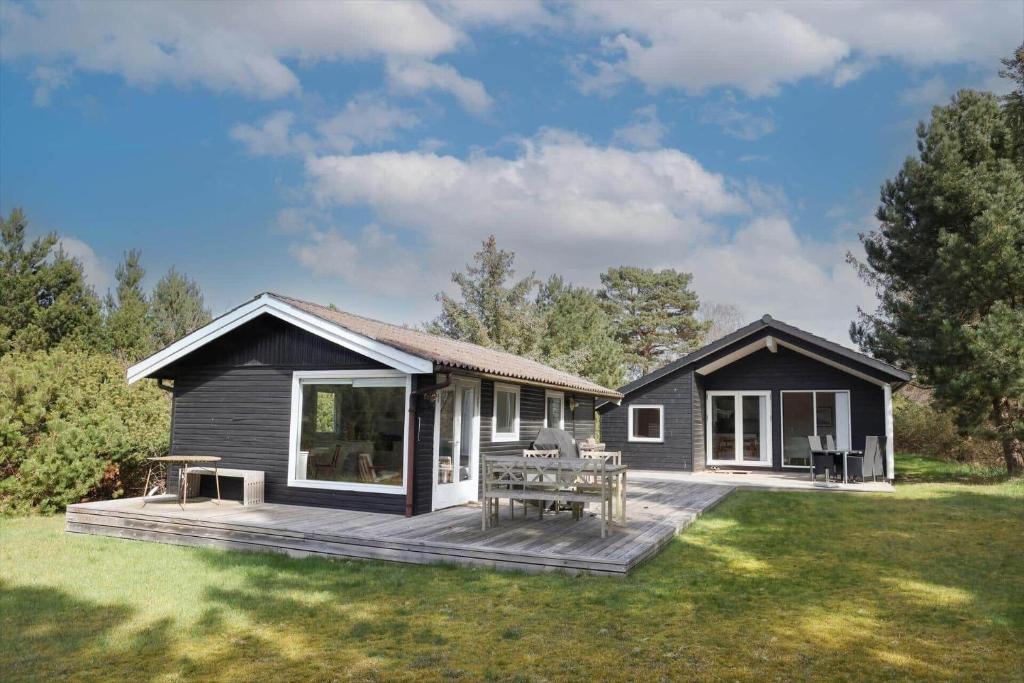 a small house with a deck in the yard at 11120-1-Nykobing-Sj-Birkehaekken-9 in Nykøbing Sjælland