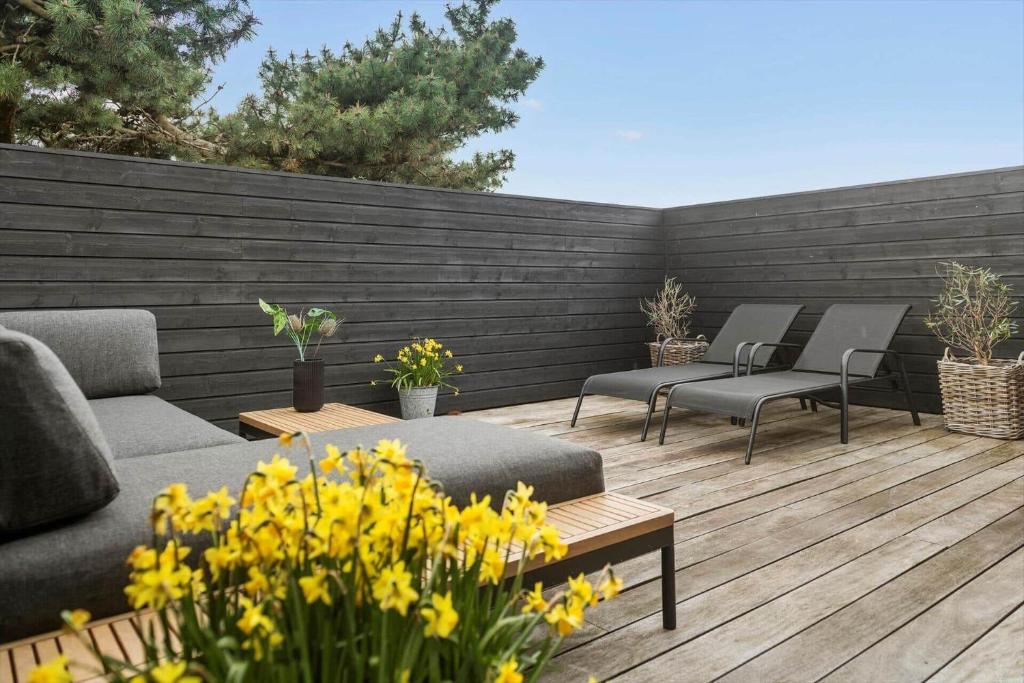 凡岛FAN006-Fano-Gogevej-43的露台上的木质甲板上摆放着沙发和鲜花