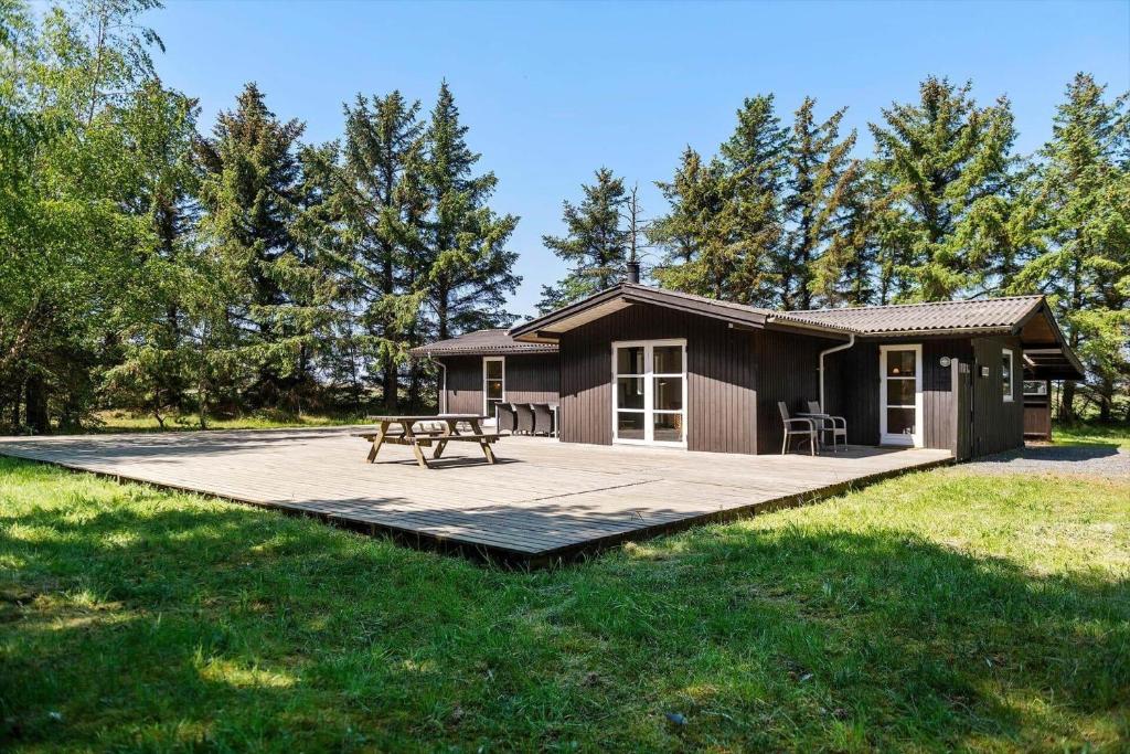 una cabaña con una mesa de picnic delante de ella en FAN040-Fano-Nymarken-1, en Fanø
