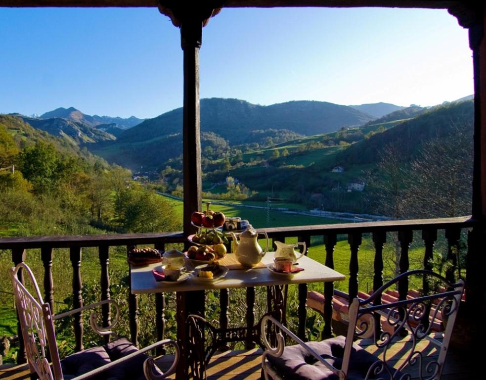 una mesa en un balcón con vistas a las montañas en La Casona de Con, en Mestas de Con
