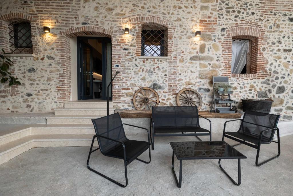 a group of chairs and a table in front of a building at Alma Room in Colceresa