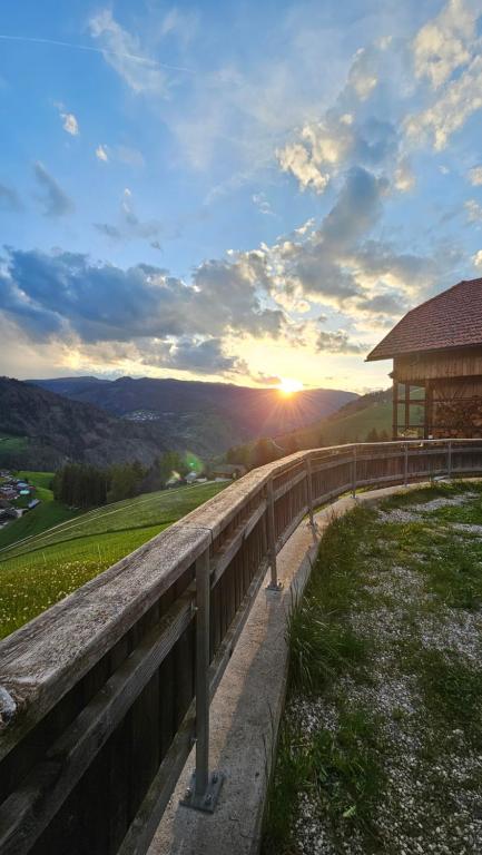 a sunset over a hill with a wooden fence at Panorama Dolomiti in San Vigilio Di Marebbe